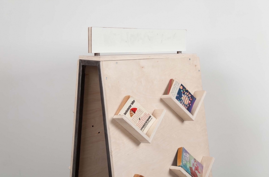 Wood book display with angled shelves with reading materials displayed.