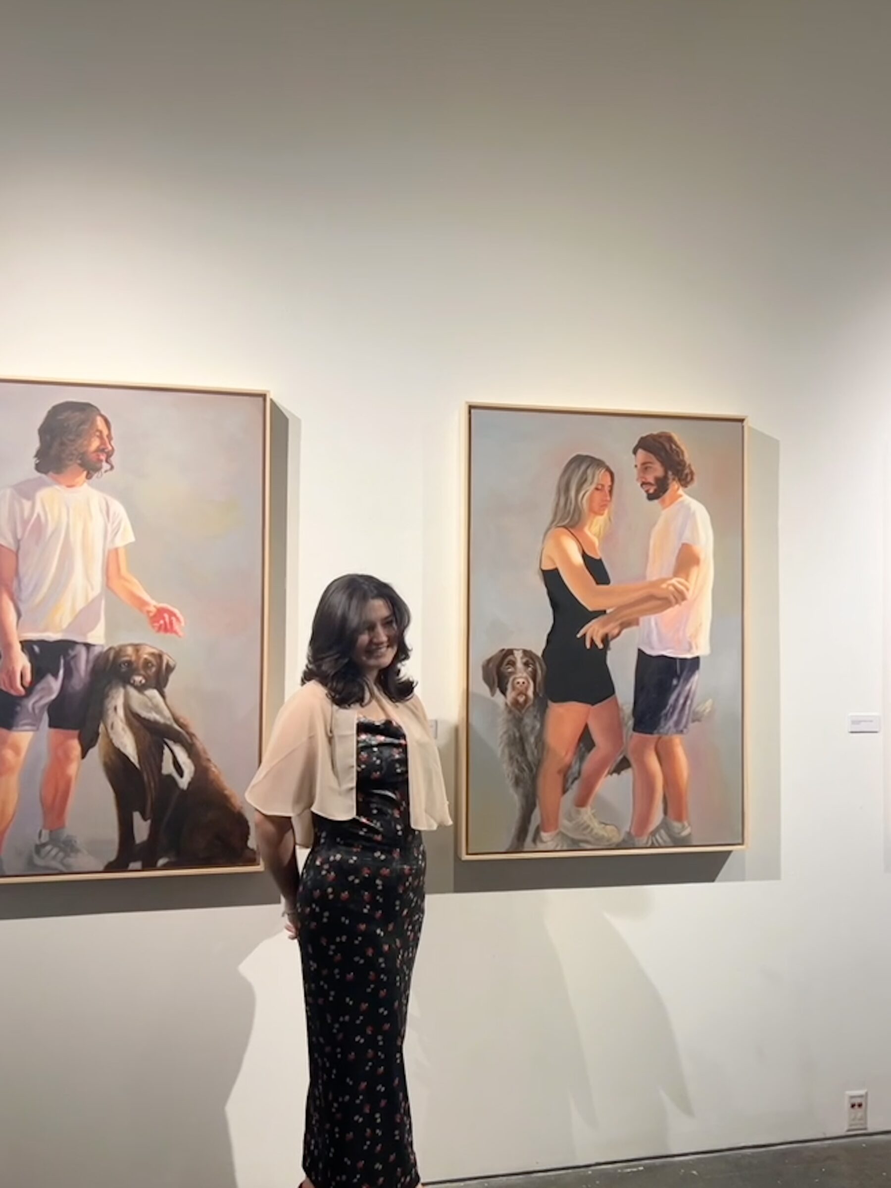 Photo of Emma standing in front of paintings
